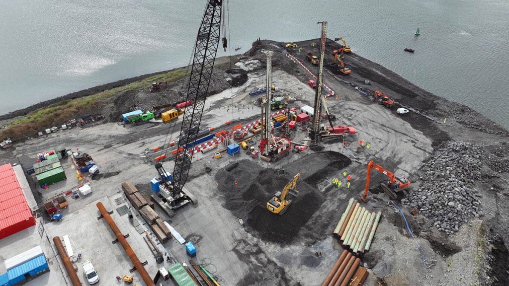 Piling rigs and crawler crane working on the reclaimed platform