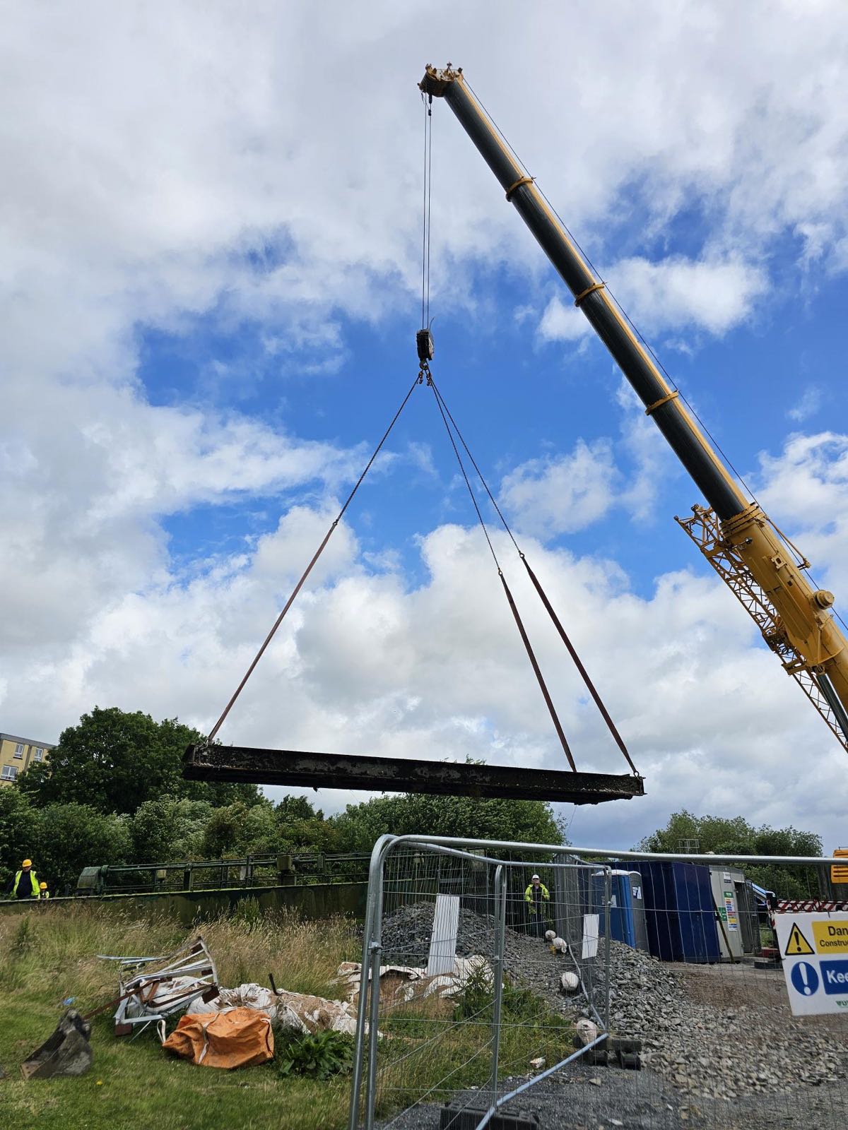Crane lifting a flood defence gate beam into position