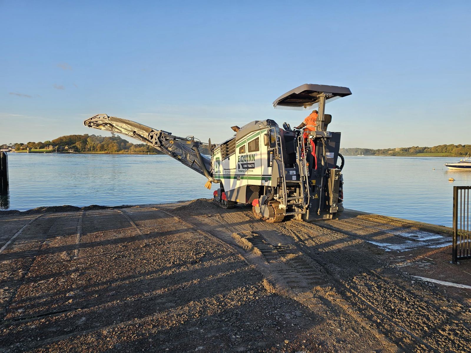 Road planer resurfacing the slipway at golden hour